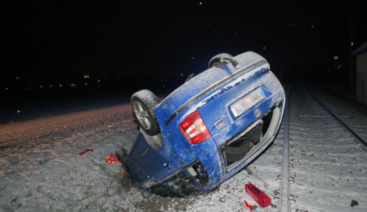 Mladá řidička dostala smyk na zasněžené silnici. Auto se převrátilo na střechu