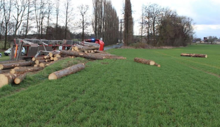Řidič kamionu vjel do příkopy a převážené klády skončily v poli