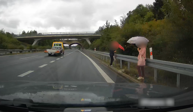 VIDEO: Dvě ženy si to v dešti vykračovaly po dálnici D6, měly obrovské štěstí, že je nesmetlo auto