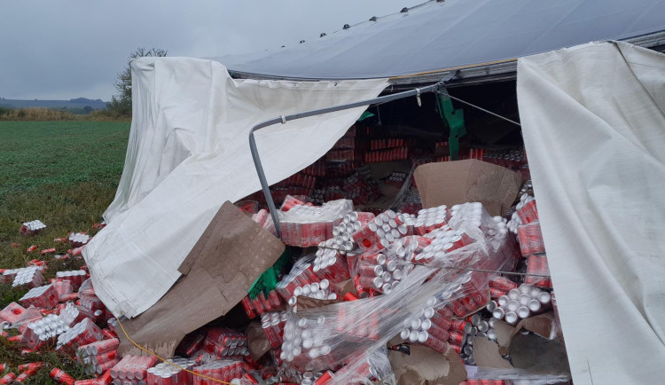 Na pole se vysypaly stovky plechovek Coca-Coly z převráceného kamionu