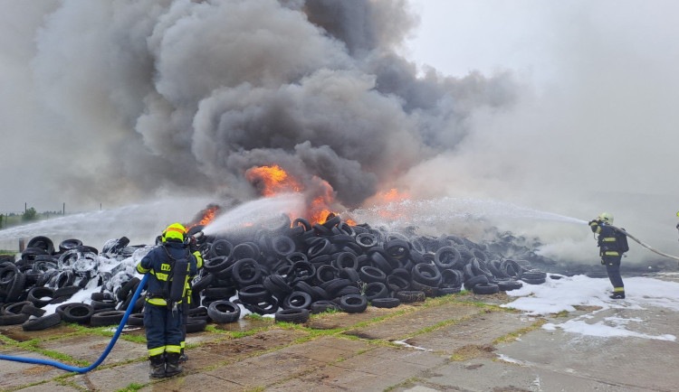 Hasiči bojují s rozsáhlým požárem pneumatik, černý kouř je vidět na kilometry daleko