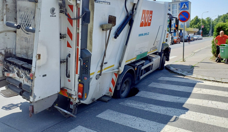 V Kobylisích se pod popelářských autem propadla silnice, musí ho vytáhnout jeřáb