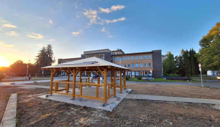 Nevzhledná travnatá plocha před nemocnicí se mění v park s altánem